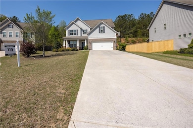 View of front of home featuring concrete driveway and a porch