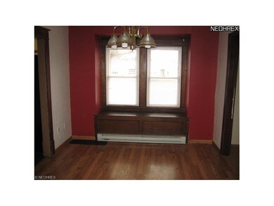 Dining area has laminate flooring and window seat.