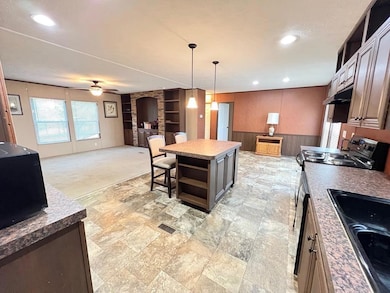 Kitchen featuring open shelves, stainless steel e