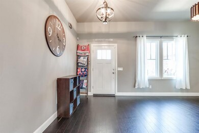 Entryway with an inviting chandelier and dark hardwood / wood-style flooring