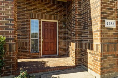 Entrance to property featuring brick siding and a porch