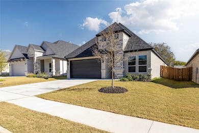French provincial home featuring brick siding, driveway, a garage, and roof with shingles