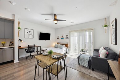 Living area featuring a ceiling fan, light wood f