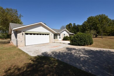 Ranch-style house with a garage and a front lawn