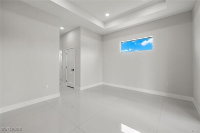 Tiled spare room with baseboards, a raised ceiling