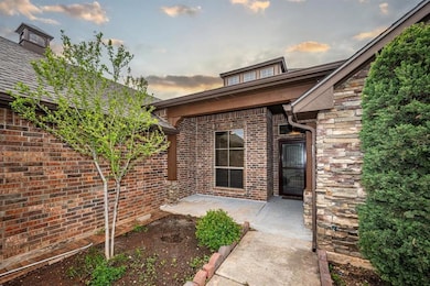 Exterior entry at dusk with brick siding and a pat