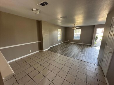 Empty room with ceiling fan, hardwood / wood-style flooring, and a textured ceiling