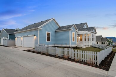 View of front facade featuring driveway, a shingled roof, a fenced front yard, a garage, and covered porch