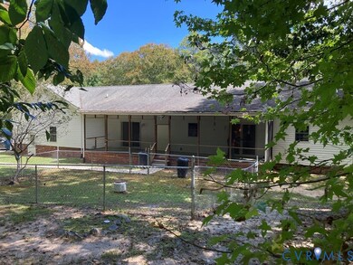 Rear view of property with a fenced front yard, a gate, and a shingled roof
