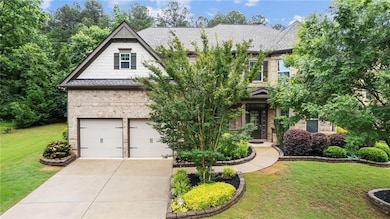 View of front of property featuring a front yard, an attached garage, and driveway