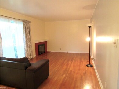 Hardwood floors in living room with a corner firep