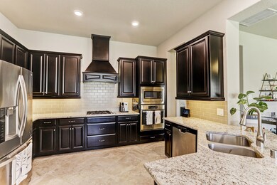 Chef's kitchen is large with plenty of counter space and room to move around while cooking. Stainless steel appliances add to the modern look.