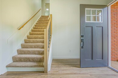 Entrance foyer with brick wall and hardwood / wood
