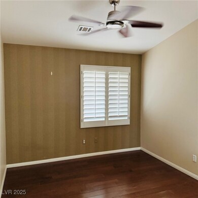 Empty room with wood finished floors, a ceiling fa