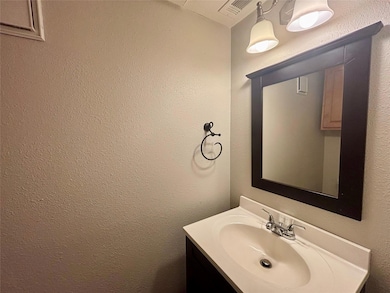 Bathroom featuring vanity and a textured wall