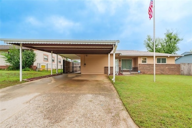 View of front of house with concrete driveway, brick siding, and a carport