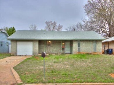 Ranch-style home featuring a garage and a front lawn