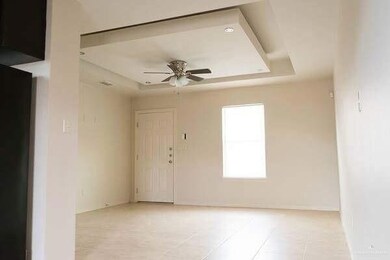 Spare room with a tray ceiling, ceiling fan, and light tile patterned flooring