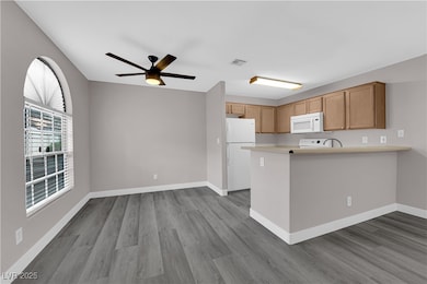 Kitchen with a peninsula, white appliances, visibl