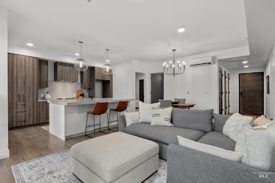 Living room featuring recessed lighting, light wood-type flooring, a chandelier, and a wall mounted AC