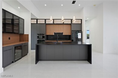 Kitchen with fridge, wine cooler, sink, hanging li