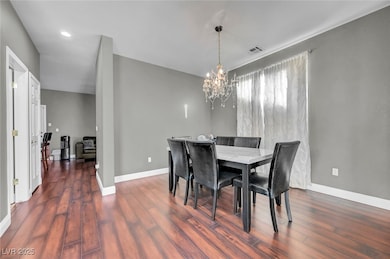 Dining area featuring a chandelier, dark wood-style flooring, and recessed lighting