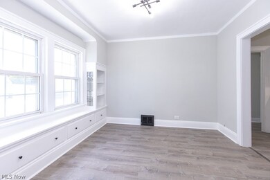 Empty room featuring hardwood / wood-style floors and ornamental molding
