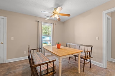 Dining space featuring wood finished floors, ceiling fan, and a textured ceiling