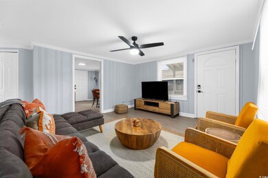 Living room with ornamental molding, hardwood / wo