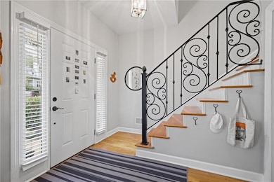 Entrance foyer with light wood-style floors and stairs