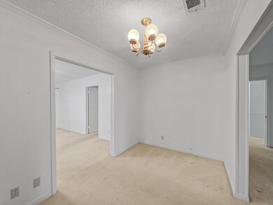 Dining room with crown molding, a chandelier, a te