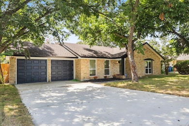 Ranch-style home featuring a garage, a front lawn, concrete driveway, and brick siding