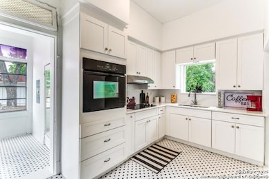 Kitchen with black appliances, light countertops,
