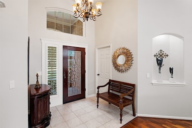 Front entry of home features tile flooring with custom decorative lead glass front door.