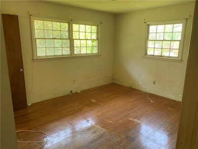 Unfurnished room featuring hardwood / wood-style flooring and baseboards
