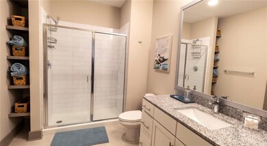 Bathroom featuring a shower with shower door, vani