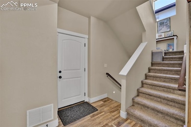 Foyer entrance with visible vents, light wood fini