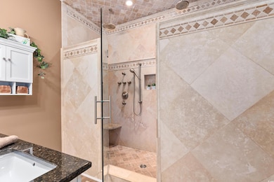 Full bath with tiled shower and a sink