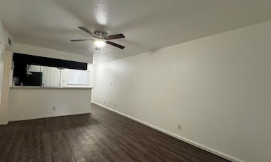 Unfurnished living room with dark wood-style floo