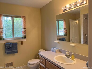 Bathroom with vanity, a shower, and tile patterned flooring