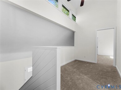 Carpeted spare room featuring a ceiling fan and a high ceiling