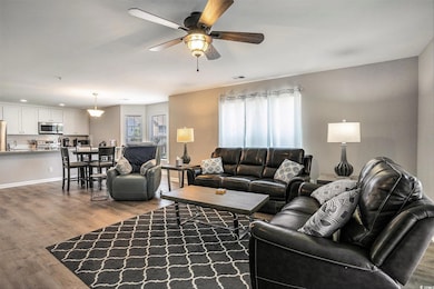 Living area with ceiling fan and wood finished floors