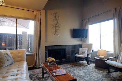Living area featuring a tile fireplace and vaulted
