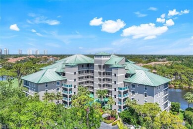 View of apartment building / complex featuring view of wooded area and a water view