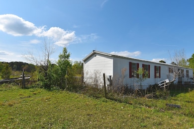 View of side of home featuring fence and a yard