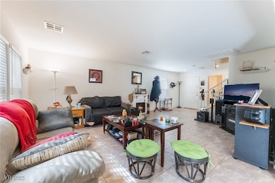Living area with light tile patterned floors and stairway