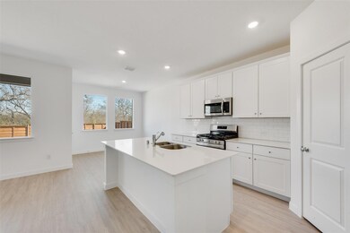 Kitchen with white cabinetry, sink, stainless stee