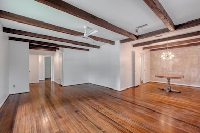 Unfurnished living room with beamed ceiling, hard