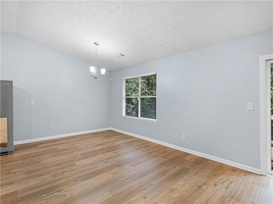 Unfurnished dining area with light wood-style flooring, lofted ceiling, a chandelier, and a textured ceiling