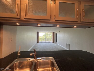 Kitchen featuring carpet flooring, baseboards, a s